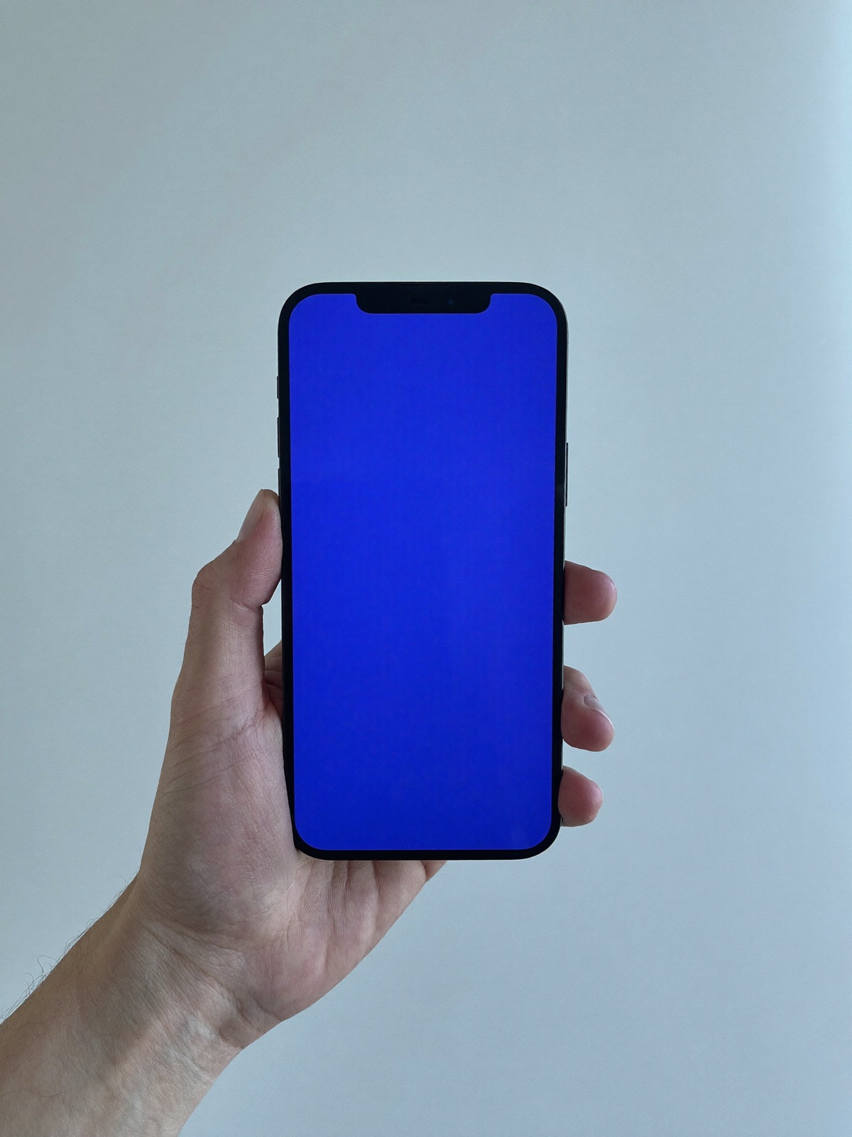 Hand holding a phone with a blue screen